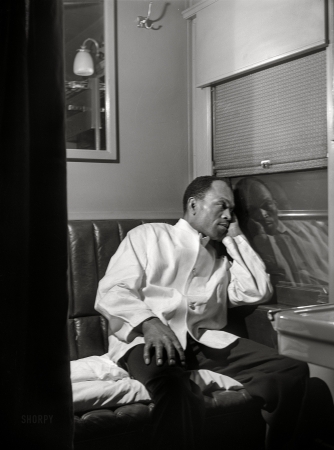 Photo showing: The Night Porter -- March 1942. Alfred MacMillan, Pullman porter resting in the
men's washroom aboard the 'Capitol Limited' bound for Chicago.