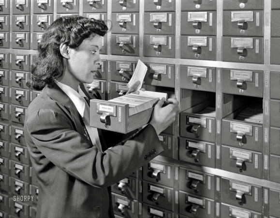 Photo showing: File M for Mazique -- Winter 1942. Washington, D.C. Jewel Mazique on temporary duty checking filing systems in the Library of Congress.