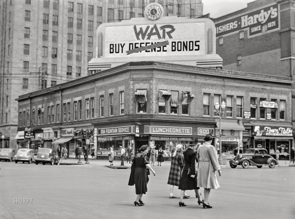 Photo showing: Buy War Bonds -- May 1942. Street corner in downtown Lincoln during University of Nebraska commencement week.