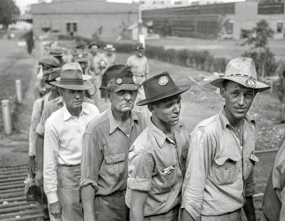 Photo showing: Checking Out - -- June 1942. Wilson Dam, Alabama (Tennessee Valley Authority).
Workers checking out at end of shift at a chemical engineering plant.