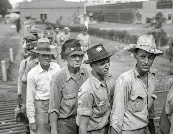Photo showing: Checking Out - -- June 1942. Wilson Dam, Alabama (Tennessee Valley Authority).
Workers checking out at end of shift at a chemical engineering plant.