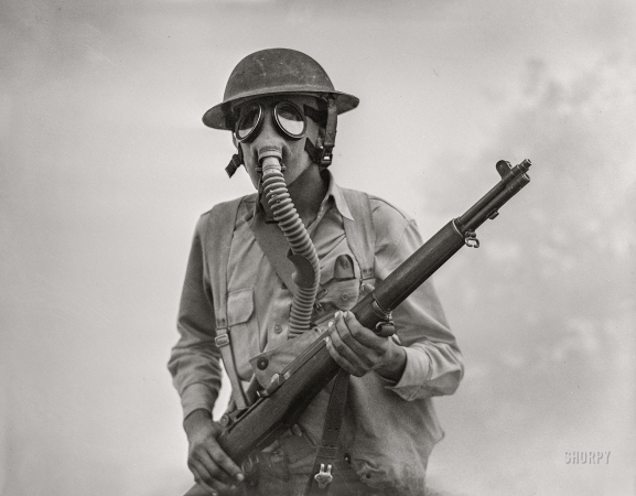 Photo showing: The Fog of War -- April 1942. Fort Riley, Kansas. Soldier of a cavalry rifle unit going through smokescreen.