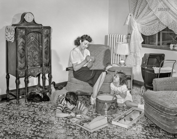 Photo showing: Family Room. -- June 1942. Brooklyn, New York. Red Hook housing development.
Mrs. Caputo and her children in the living room of their apartment.
