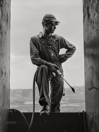 Photo showing: Young Tacker -- July 1942. Decatur, Alabama. Ingalls Shipbuilding Co. A young tacker working on one of the barges.