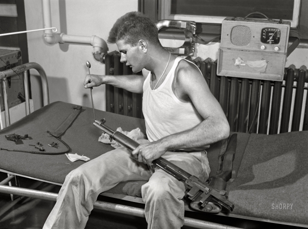 Photo showing: Lock, Stock and Barrel -- September 1942. Fort Belvoir, Virginia. Sergeant George Camplair cleans his rifle regularly.