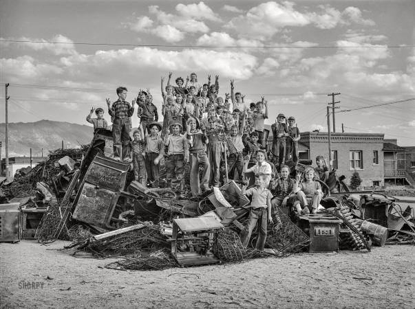 Photo showing: To Herr With Love -- October 1942. Butte, Montana. Schoolchildren on a pile of scrap which they gathered during the salvage campaign.