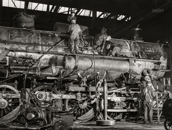 Photo showing: Engine of Change -- November 1942. Chicago, Illinois. In the roundhouse at an Illinois Central
Railroad yard. This former switching engine is being rebuilt for use on the road.