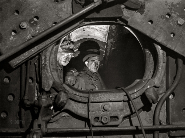 Photo showing: Boilermakers -- December 1942. Boiler makers inside the firebox of a locomotive at the Chicago and North Western roundhouse.