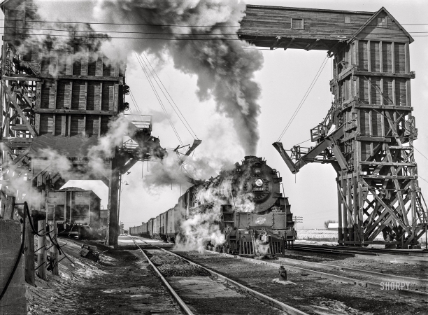 Photo showing: Feed Me -- January 1943. Nelson, Illinois. Chicago and North Western Railroad freight stopping for coal and water.