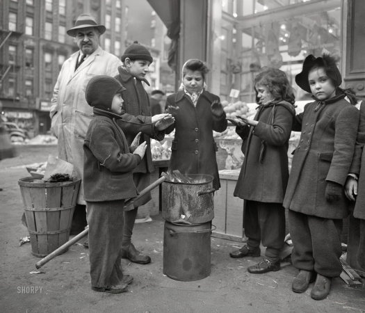 Photo showing: Small Fry - -- February 1943. New York. Italian-American children warming their hands
by fruit stand outside a grocery store at First Avenue and Tenth Street.