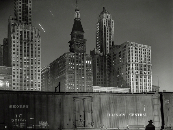 Photo showing: Special Agent -- May 1943. Chicago. Special agent making his rounds at night
at the South Water Street freight terminal of the Illinois Central Railroad.