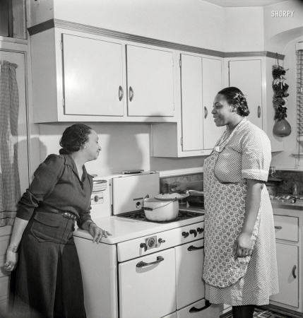 Photo showing: A Watched Pot -- March 1942. Washington, D.C. Teacher supervises the cooking of dinner by her maid.