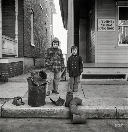 Photo showing: Plumbers Helpers -- November 1942. Lititz, Pennsylvania. Scrap collection drive. The scrap outside a plumber's house consists of pipes.