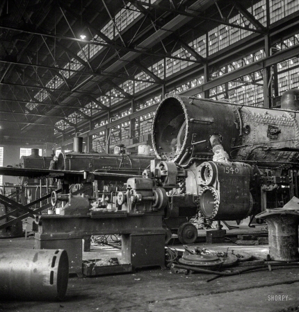 Photo showing: In for Overhaul -- December 1942. Chicago, Illinois. In the Chicago & North Western locomotive repair shops.