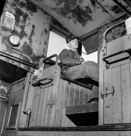 Photo showing: Rear Brakeman -- March 1943. Walter V. Dew, rear brakeman, on the Atchison, Topeka & Santa Fe
between Chicago and Chillicothe, Illinois, watching the train from the cupola.