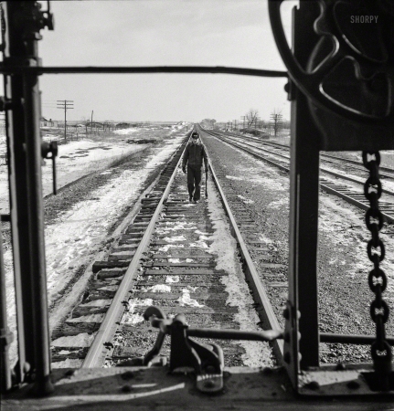 Photo showing: Santa Fe Flagman -- March 1943. Baring, Missouri. A flagman returning to a train on the Atchison, Topeka & Santa Fe.