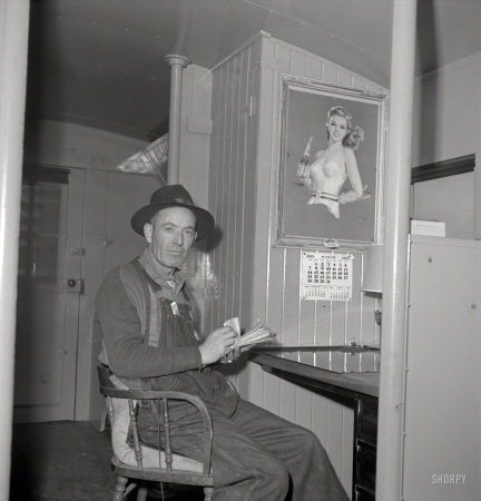 Photo showing: Pinned -- March 1943. Conductor G. Reynolds, checking his waybills in a caboose of
the Atchison, Topeka & Santa Fe Railroad between Argentine and Emporia, Kansas. 