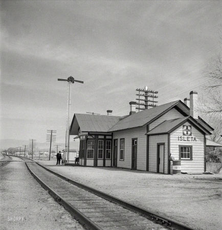 Photo showing: Message Pending -- March 1943. Isleta, New Mexico. The Santa Fe depot. Horizontal arms on pole
indicate a 'red beard,' that is a message is to be picked up by the train crew.