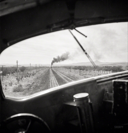 Photo showing: Smoke Signal -- March 1943. Ash Fork, Arizona. Passing an eastbound freight between Winslow and Seligman.