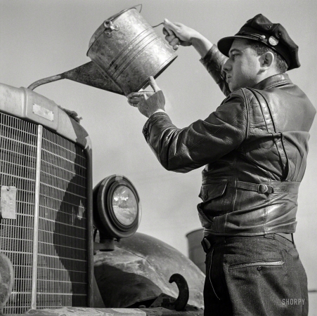 Photo showing: A Drink for Baby -- March 1943. Truck driver putting water in his radiator along Route 29 in North Carolina en route to Charlotte.