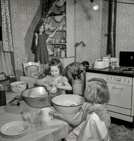 Photo showing: Sisters Grimm -- May 1943. Buffalo, N.Y. Patsy Grimm helping with housework. Their
mother, a 26-year-old widow, is a crane operator at Pratt and Letchworth. 