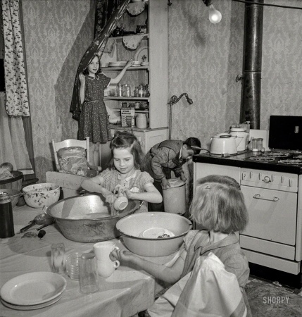 Photo showing: Sisters Grimm -- May 1943. Buffalo, N.Y. Patsy Grimm helping with housework. Their
mother, a 26-year-old widow, is a crane operator at Pratt and Letchworth. 