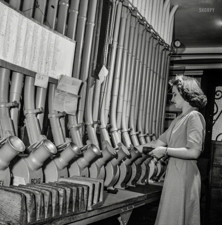 Photo showing: A Series of Tubes. -- June 1943. Washington, D.C. Miss Helen Ringwald, employee at the Western Union telegraph office,
works with the pneumatic tubes through which messages are sent to branches in other parts of the city for delivery.
