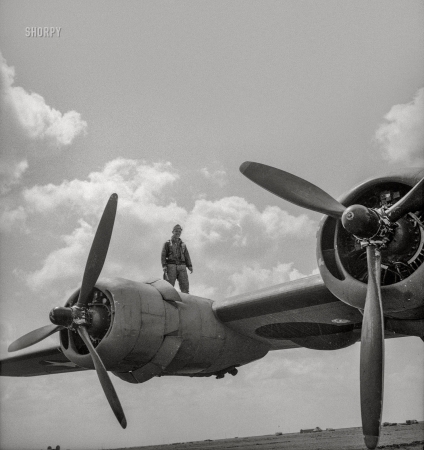 Photo showing: Wingman: 1943 -- April 1943. Airman on wing of B-24 bomber at U.S. Army 9th Air Force base somewhere in Libya.