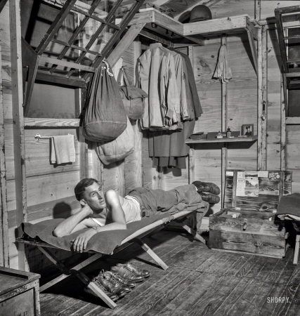 Photo showing: Cornerman -- July 1943. Greenville, South Carolina. Air Service Command. Enlisted man of the 25th Service Group relaxing in his hutment.