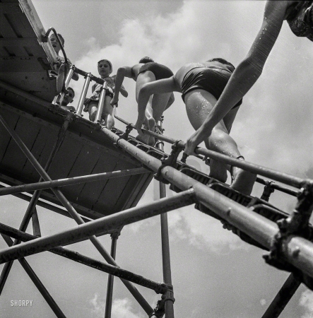 Photo showing: Modern Photography -- July 1943. Climbing the ladder to the sliding board at the Glen Echo swimming pool.