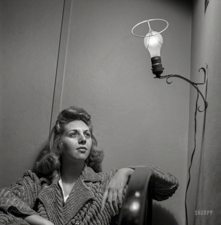 Photo showing: Electric Angel -- January 1943. Washington, D.C. This Office of Price Administration clerk, speaking of her
boardinghouse room, says: 'The light looks like an angel when I leave the shade off, so I do so'.