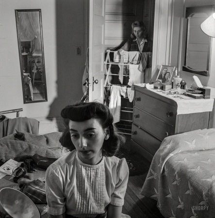 Photo showing: Pardon My Rack -- January 1943. Washington, D.C. Girl in the doorway of her room
at a boarding­house. With photographer Esther Bubley front and center.