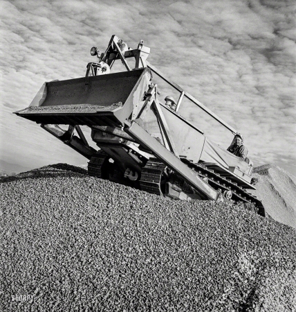 Photo showing: Cats of War -- November 1942. Columbia Steel Company at Geneva, Utah. Bulldozer
handling gravel for concrete during construction of a new steel mill.