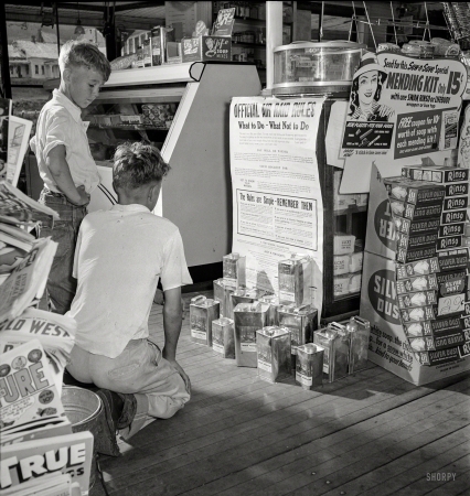 Photo showing: Air Raid Rules -- July 1942. West Danville, Vermont. Guy Davenport, 11, and Maynard Clark, 14, reading
the air raid instructions posted in Gilbert S. Hastings' post office and general store. 