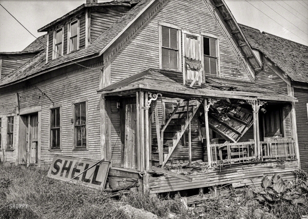 Photo showing: Porch 911 -- August 1939. West Danville, Vermont. A farmhouse with stairway leading to the second floor through the porch roof.