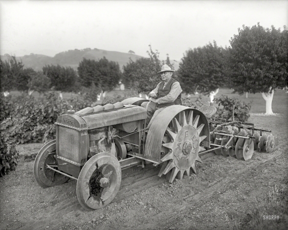 Photo showing: The Squeaky Wheel. -- Oakland, Calif., circa 1918. Orchard tractor demonstration -- Fageol Motors Co. 'Walking Tractor'.