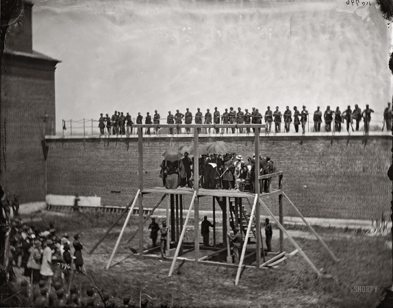 Photo showing: Time to Die -- July 7, 1865.  Gen. John F. Hartranft reading the death warrant to condemned Lincoln assassination
conspirators Surratt, Payne, Herold and Atzerodt on the scaffold at Fort McNair, Washington.