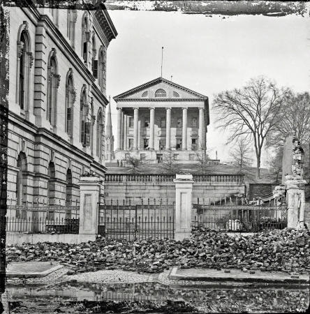 Photo showing: Richmond in Ruins -- April 1865. Fallen Richmond -- Custom House (left) and Virginia State Capitol; rubble in street.