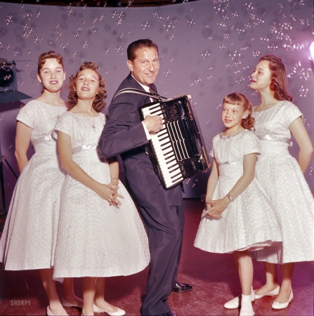 Photo showing: Champagne Music -- April 1957. Entertainer Lawrence Welk playing accordion with the Lennon Sisters.