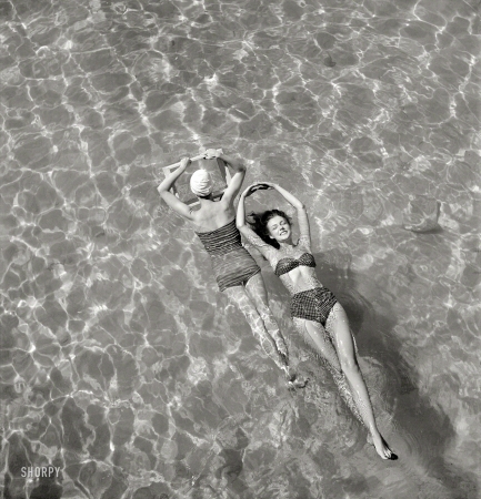 Photo showing: Wave of the Future -- October 1948. Bathing suit models in swimming pool.