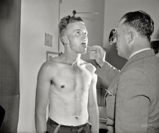 Photo showing: Raw Recruit -- Washington, D.C., June 1940. New recruit Kermit Kuhn, 21 years old, being examined by Army doctor.