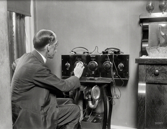 Photo showing: Neutrodyne Tweaker -- July 1924. Dr. William C. Fowler, health officer of Washington, D.C.,
tuning a Freed-Eisemann Neutrodyne Receiver, using an old car horn as loudspeaker.