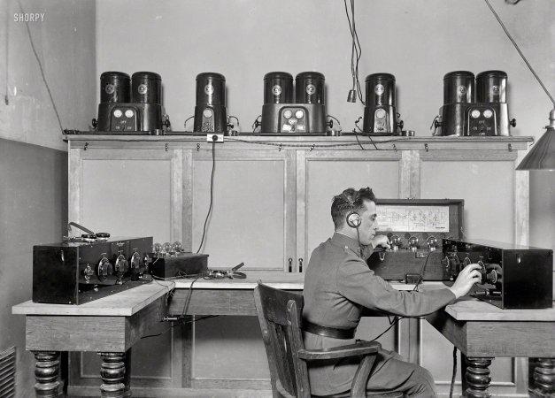 Photo showing: The Twiddler -- Washington, D.C., 1924. Tweaking the dials on a Freed Eisemann Neutrodyne receiver
and a Western Electric 138 amplifier. On the shelf: Westinghouse Rectigon battery chargers. 