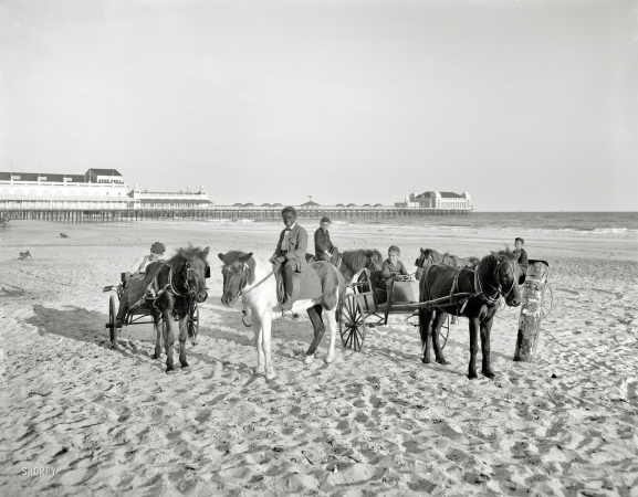 Photo showing: Pony Boys -- Atlantic City circa 1905. Ponies on the beach. In the distance, the Steeplechase and Steel piers.