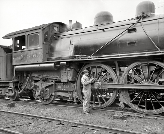 Photo showing: The Squeaky Wheel -- Michigan Central Railroad. Oiling up before the start, circa 1904.