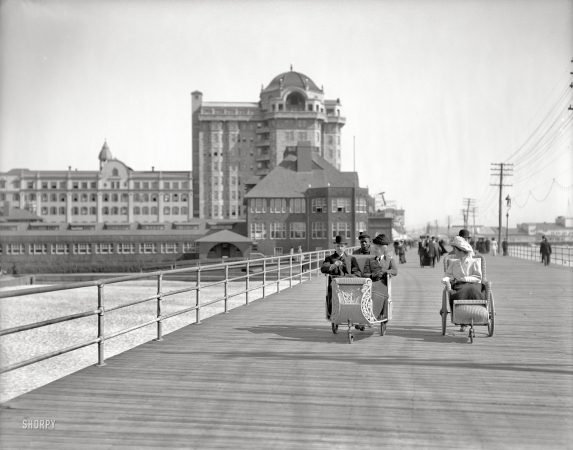 Photo showing: Atlantic City Rollers -- Circa 1906. Rolling chairs on the Boardwalk with Hotel Traymore in the background.