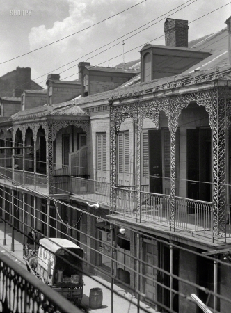 Photo showing: The Ice Wagon -- New Orleans circa 1923. Upper stories of buildings with wrought iron balconies.