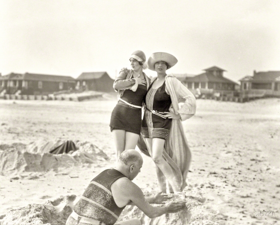 Photo showing: Filles de Mer -- Circa 1925. Man building sand castle and two women. Long Beach, New York.