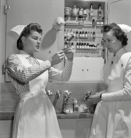 Photo showing: Nurse Needles -- November 1942. Babies' Hospital, New York. A graduate nurse
watches student Susan Petty prepare a hypodermic for a patient.