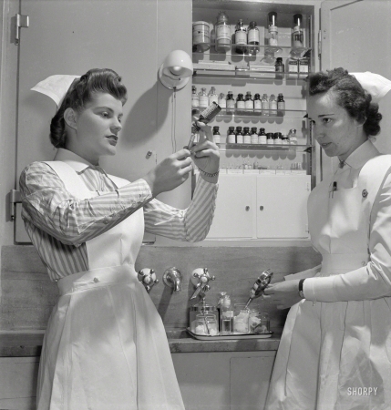 Photo showing: Nurse Needles -- November 1942. Babies' Hospital, New York. A graduate nurse
watches student Susan Petty prepare a hypodermic for a patient.